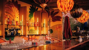 A bar area with shelves of bottles, glasses, and a polished counter. - Riad Nashira & Spa (Marrakech)