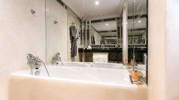 Un baño moderno con una bañera grande, una zona de ducha independiente y un tocador con espejo.