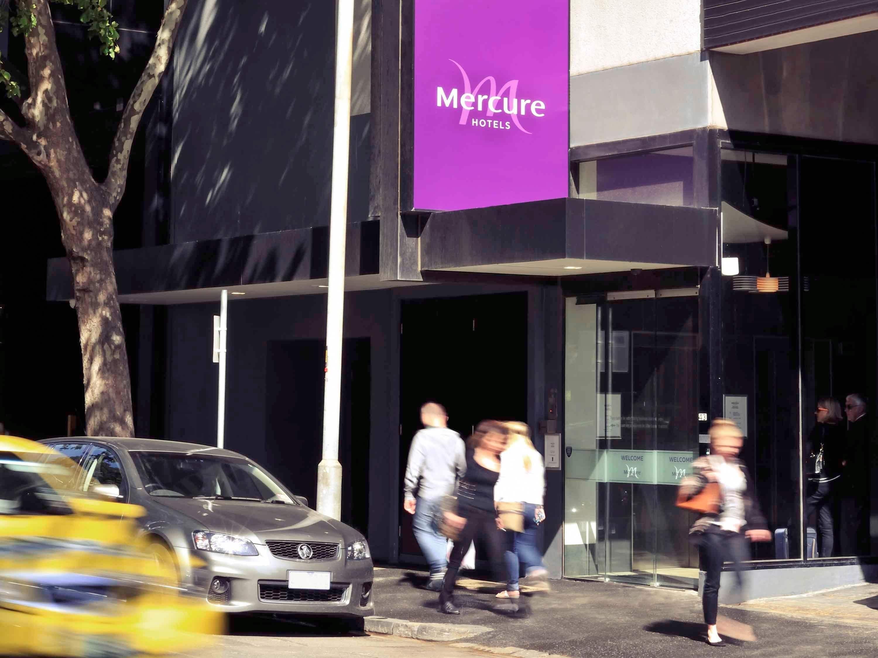 A Mercure hotel entrance with a modern facade, glass doors, and a visible reception area.
