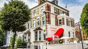 A building with a red awning and a sign that reads "OYO London Guest House." - London Guest House by OYO - Acton (London)