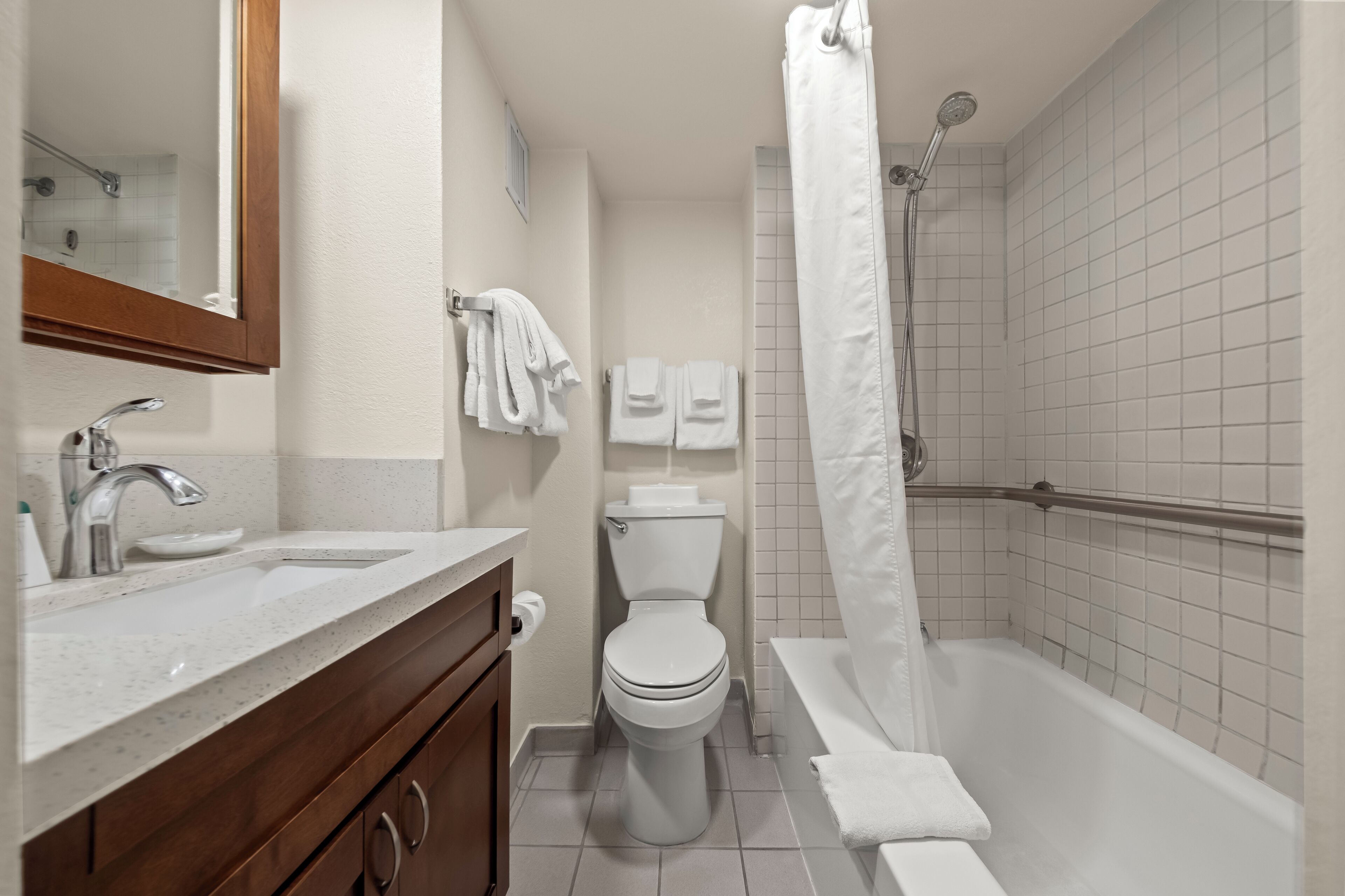 A modern bathroom with a sink, toilet, and bathtub.