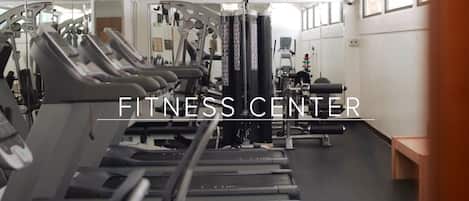 Un gimnasio con cintas de correr, máquinas de pesas y equipo de ejercicio.