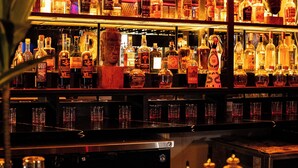 A bar area with shelves of liquor bottles and a cash register. - The Imperial Hawaii Resort (Honolulu)