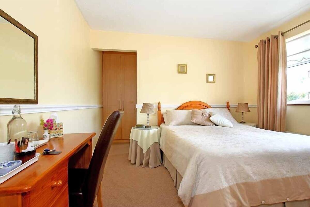 A hotel room with a bed, a desk, a chair, and a wardrobe.