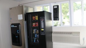 A vending machine with snacks, a refrigerator, and a thermostat.