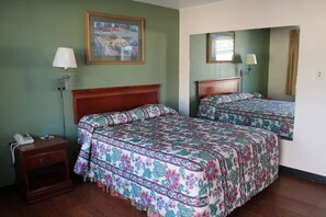 A hotel room with two beds, a nightstand with a phone, and a painting on the wall. - American Motor Inn (Rock Island)