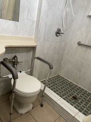 A bathroom with a toilet, a sink, and a shower. - American Motor Inn (Rock Island)