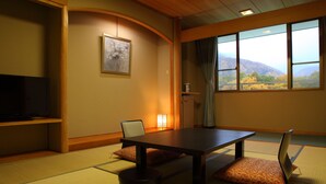 A traditional Japanese room with tatami flooring, a low table, and cushions. - Hotel Oak Forest (Hakuba)