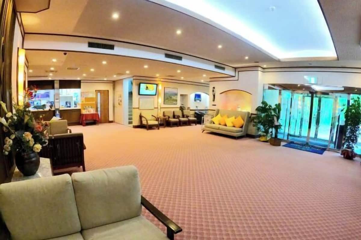 A spacious lobby with a curved ceiling, seating area, and a reception desk.