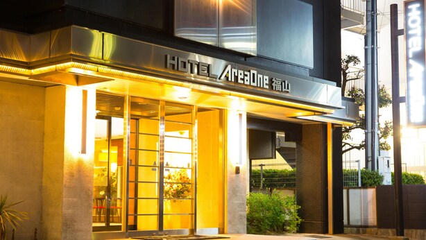 A modern hotel entrance with a glass facade, a visible reception desk, and a staircase leading to the entrance. - Hotel AreaOne Fukuyama (Fukuyama)