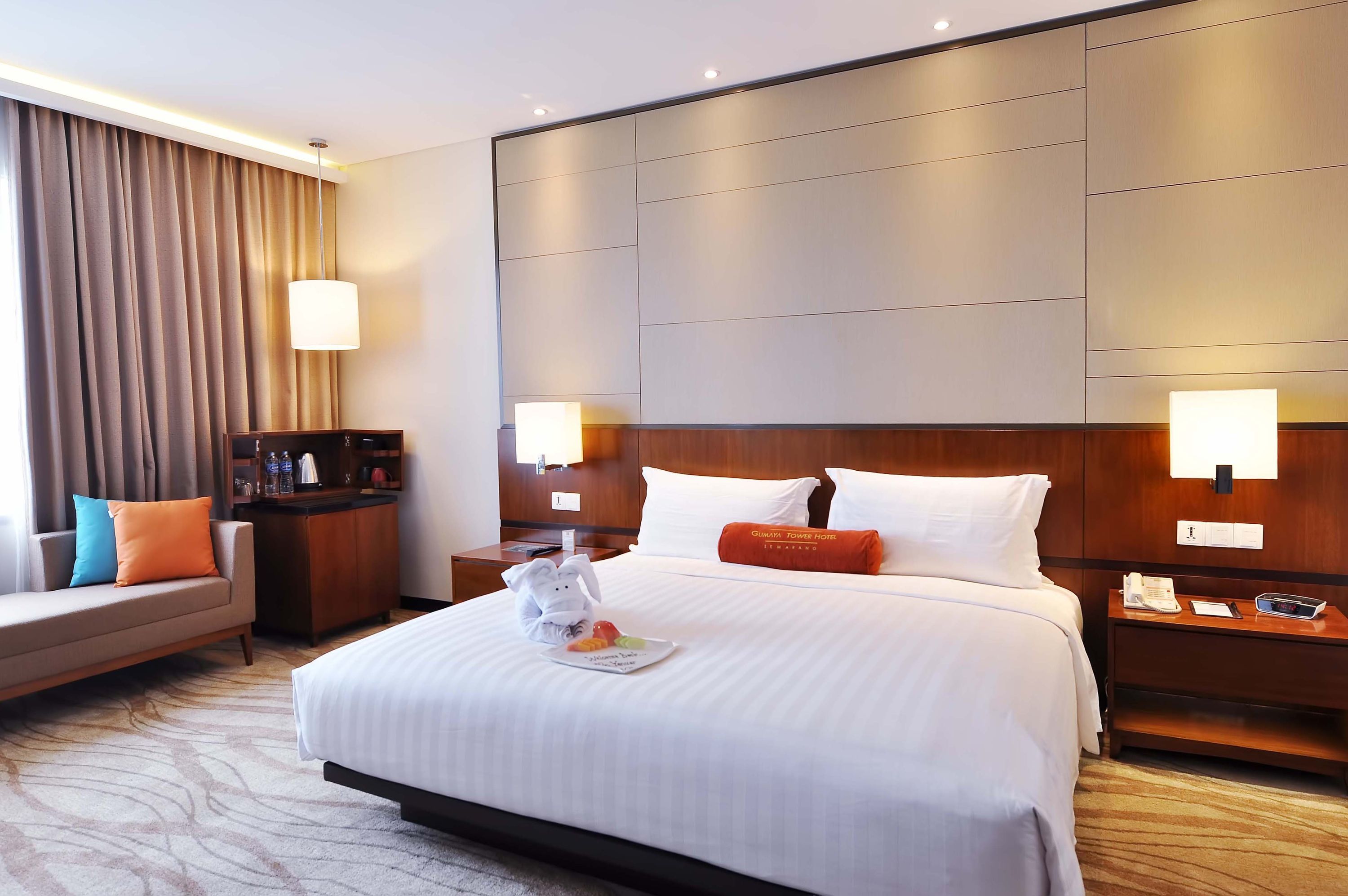 Una habitación de hotel con una cama grande, un sofá, un escritorio y una mesita de noche.