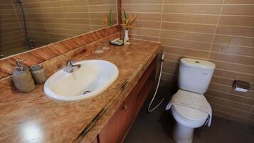 Ein Badezimmer mit Marmorwaschbecken, Toilette und Dusche.