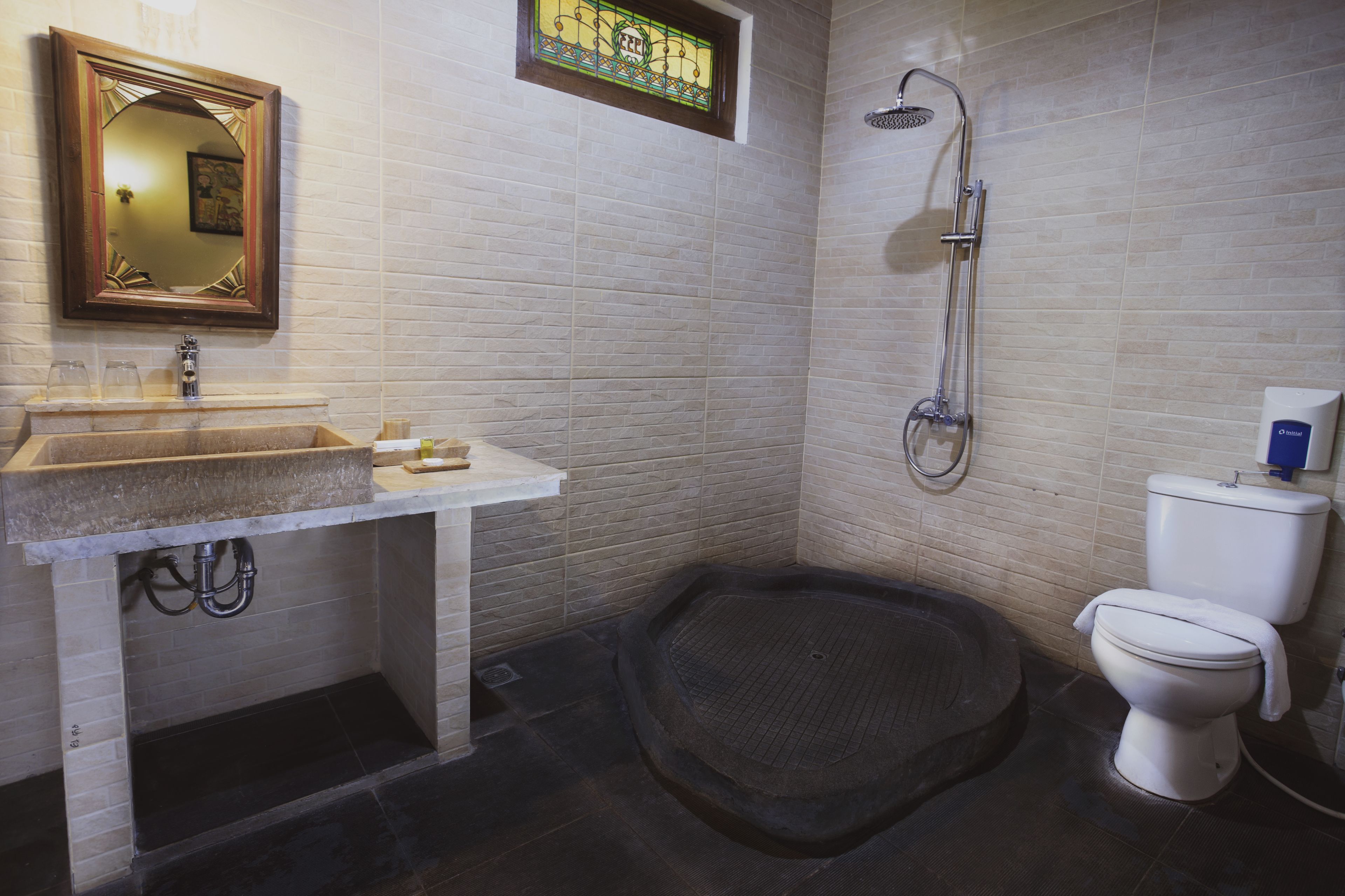 A bathroom with a sink, mirror, shower, and toilet.