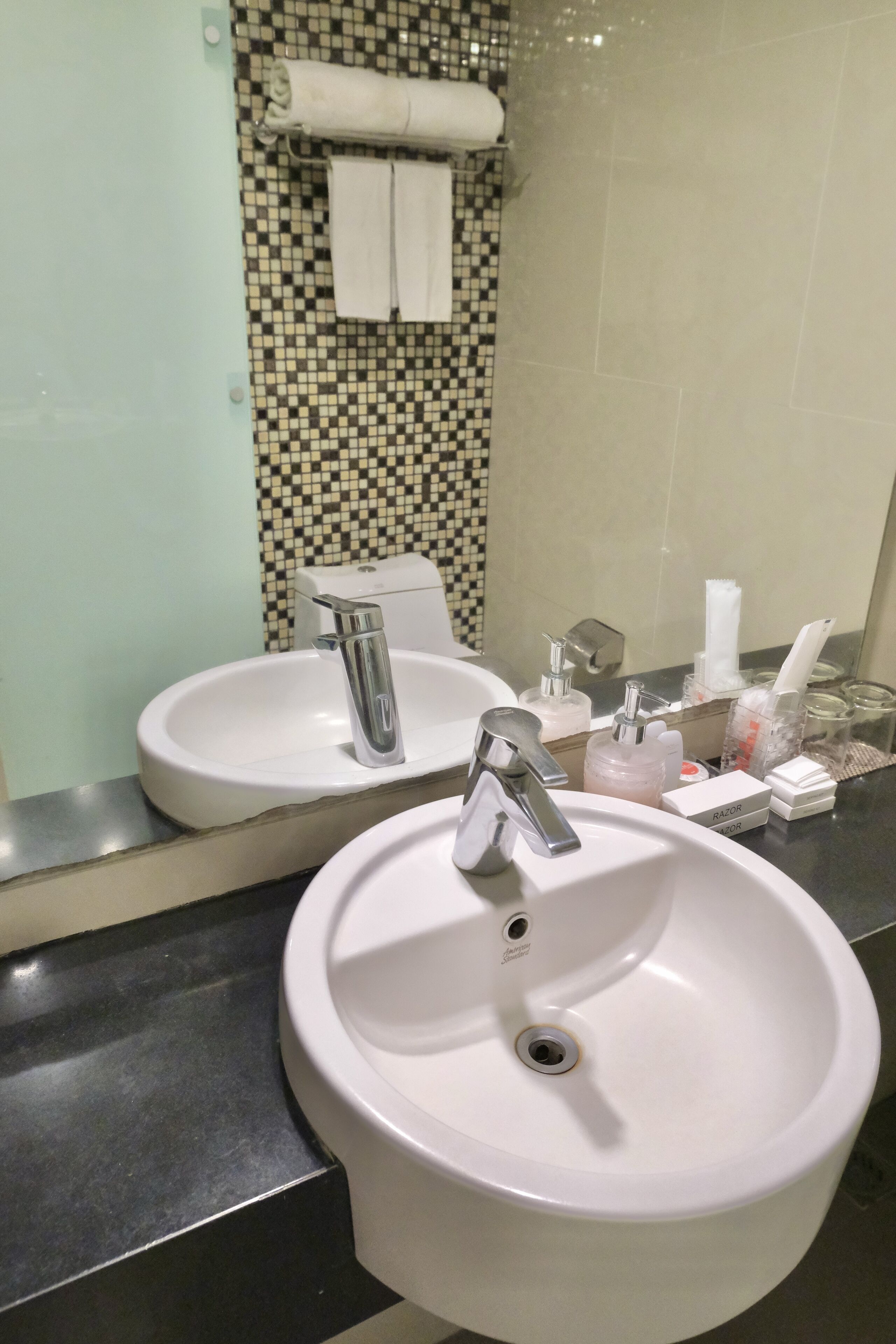 A bathroom with two sinks, a mirror, and a tiled backsplash.