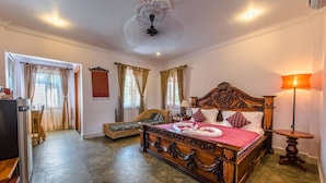 Un dormitorio amplio con una cama grande, un sofá y una zona de comedor.