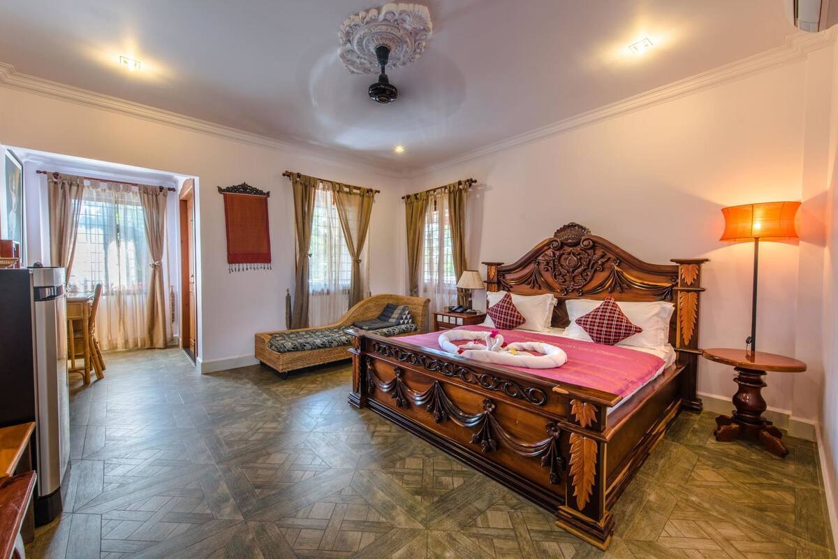 Un dormitorio amplio con una cama grande, un sofá y una zona de comedor.
