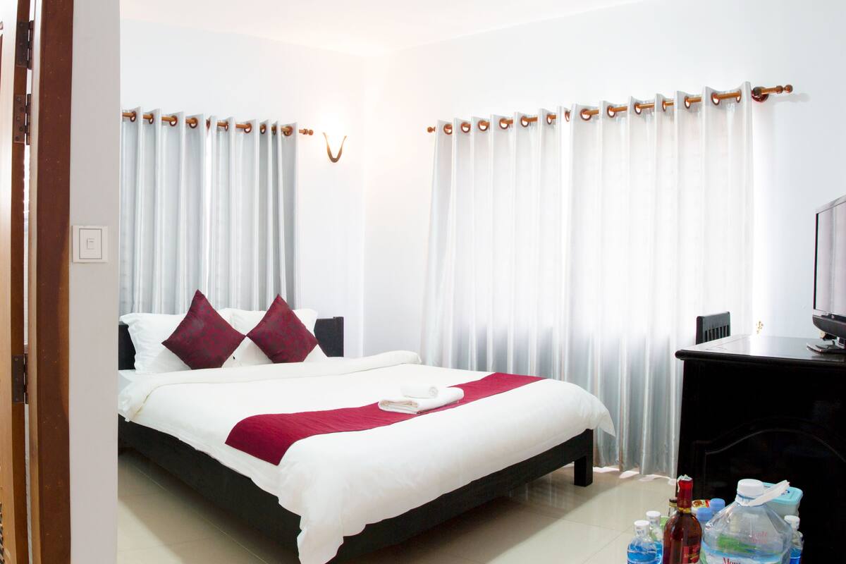 Une chambre d’hôtel équipée d’un lit, d’une télévision, d’un bureau et d’un espace douche.