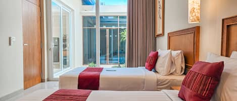 A hotel room with two beds, a large window, and a view of the outdoors.