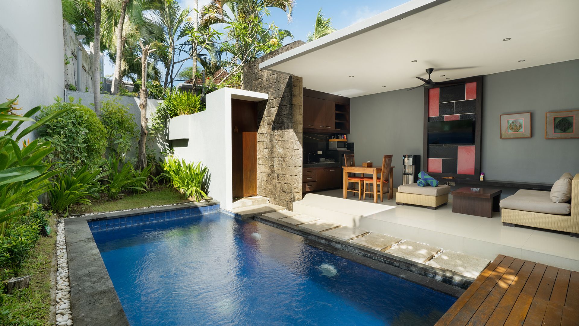 A modern house with a swimming pool, a dining area, and a living room with a sofa and coffee table.