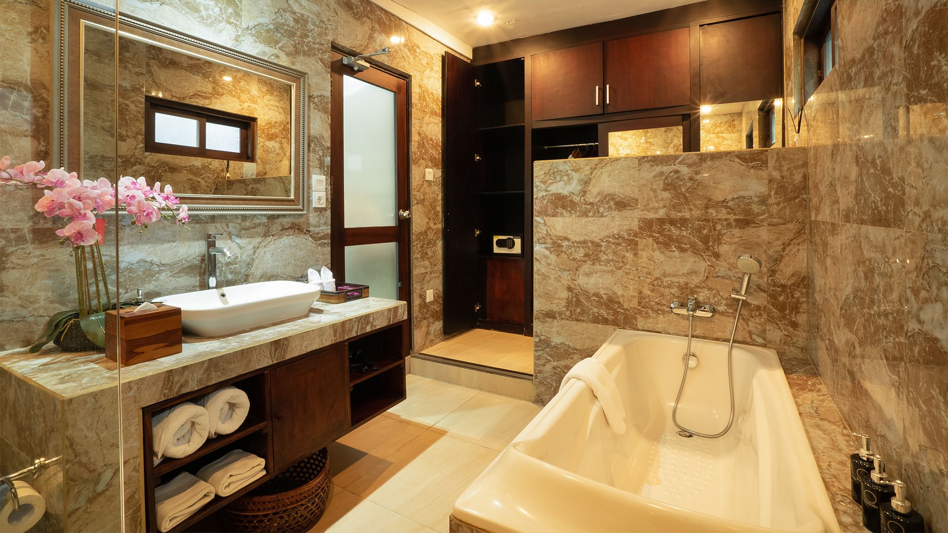 A modern bathroom with a marble sink, a large bathtub, and a walk-in shower.