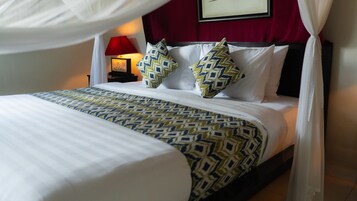 A bed with a patterned bedspread, white pillows, and a canopy.
