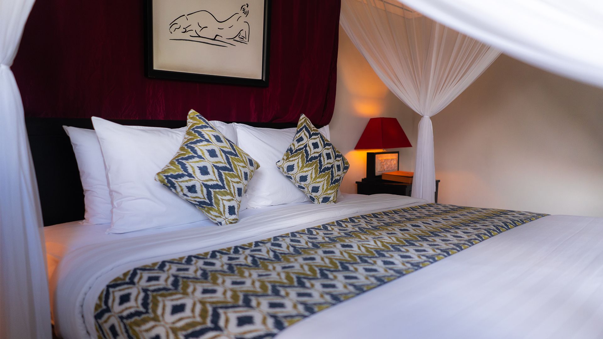 A bed with a patterned bedspread, white pillows, and a canopy.