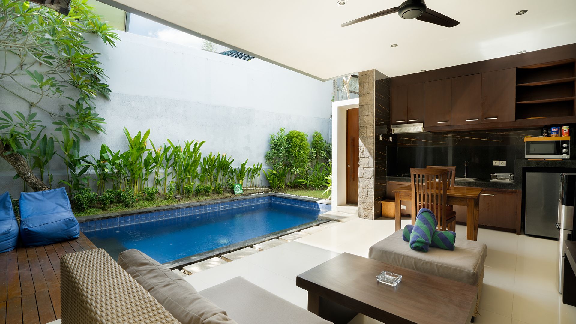 A modern kitchen with dark cabinetry, a microwave, and a refrigerator.