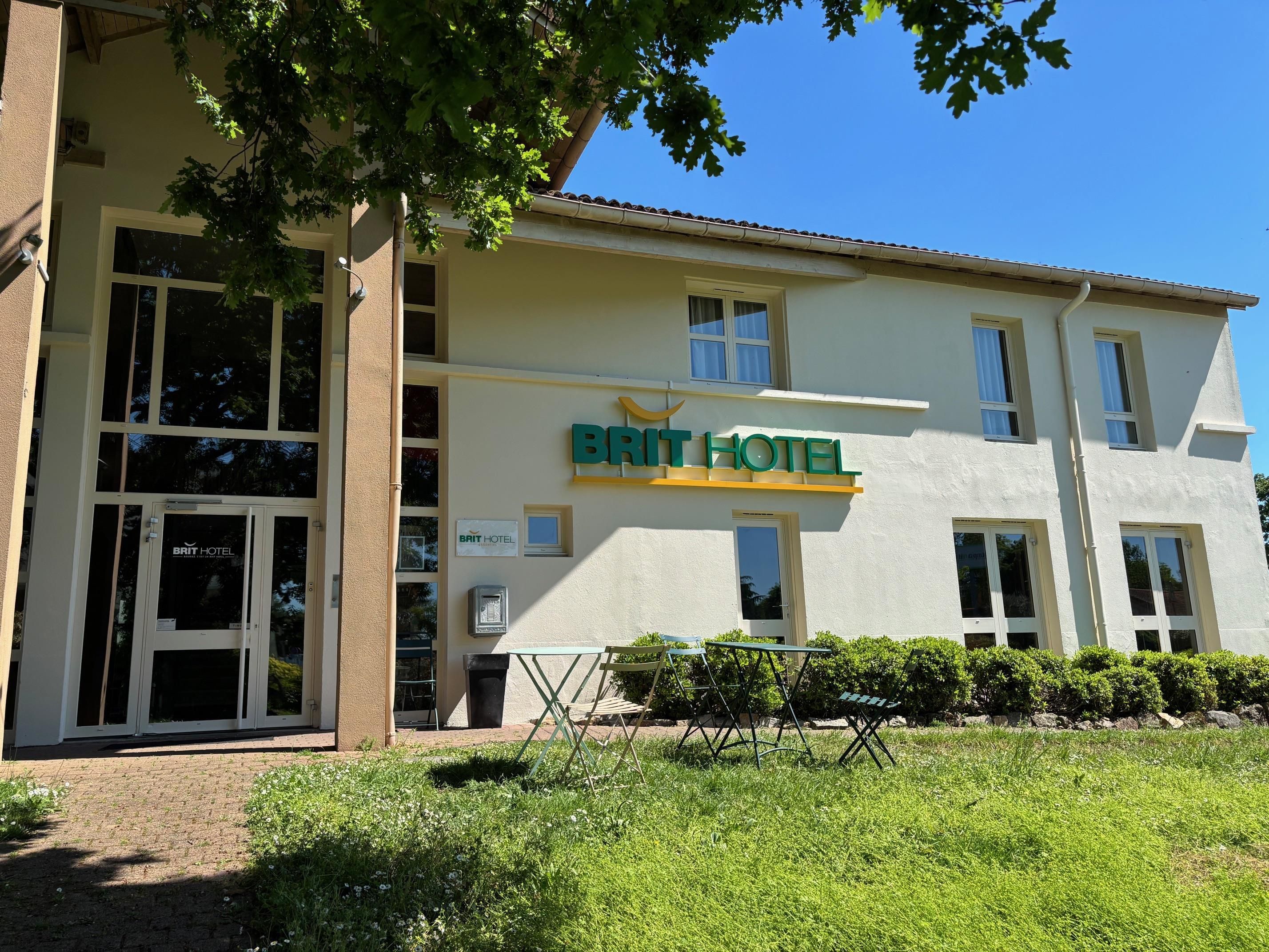 Un bâtiment d'hôtel avec une enseigne indiquant « BRIT HOTEL » et une entrée bien visible avec des portes en verre.