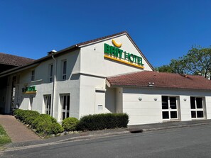 A BRITISH HOTEL building with a white facade, multiple windows, and a tiled roof. -  Brit Hotel Essentiel CHOLET (Cholet)