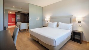 A hotel room with a bed, two bedside tables, a desk, and a chair. - Exe Convention Plaza Madrid (Madrid)