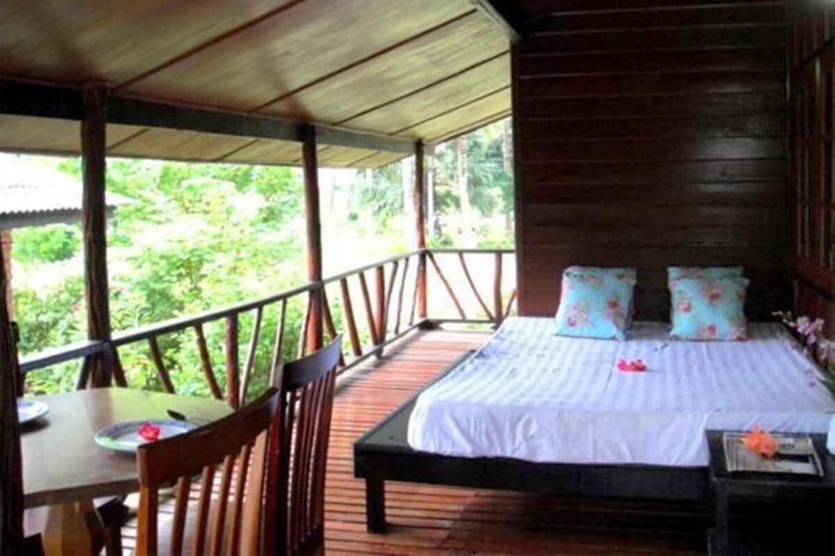 A wooden room with a bed, a table, and chairs.