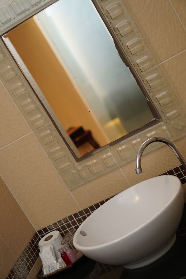 Een badkamer met een witte wasbak, een spiegel en een toilet.