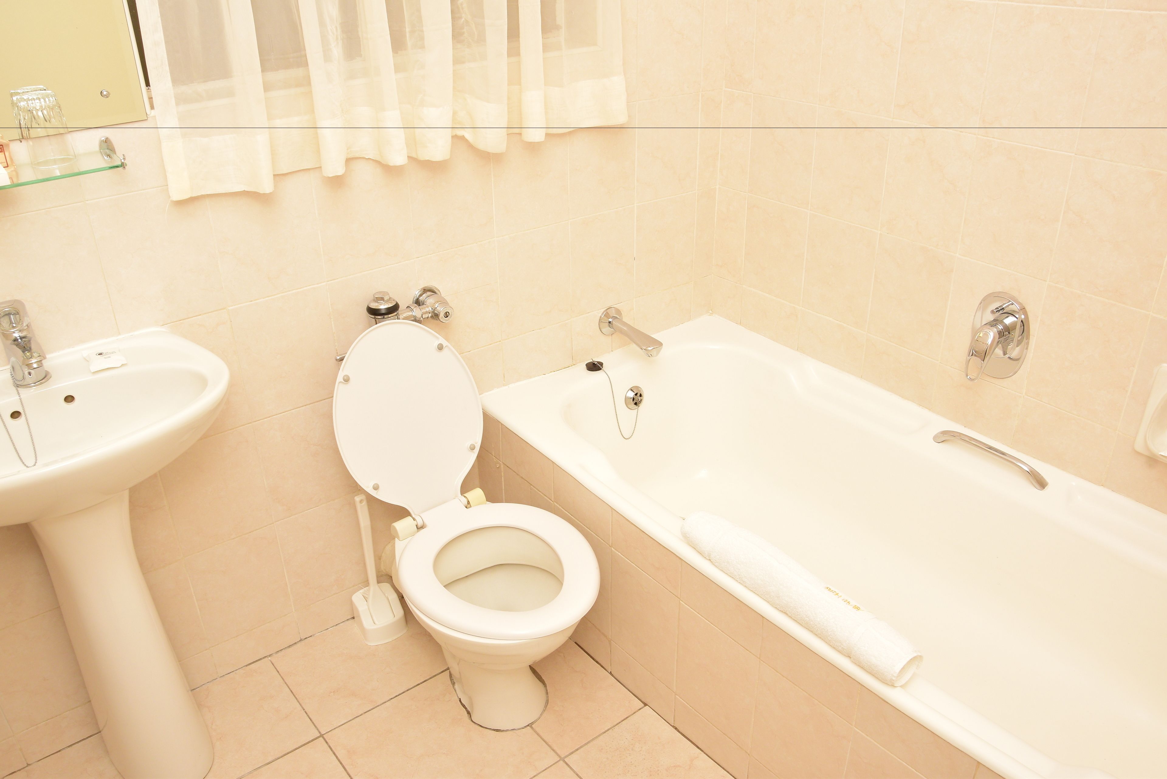 A bathroom with a toilet, sink, and bathtub.