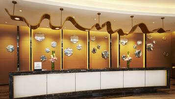 A reception desk with a modern design, featuring a marble top and a black frame.
