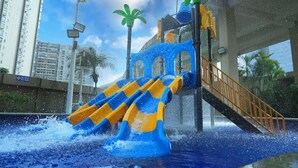 A water slide with blue and yellow sections, a staircase, and palm trees. - Hilton Foshan (Foshan)