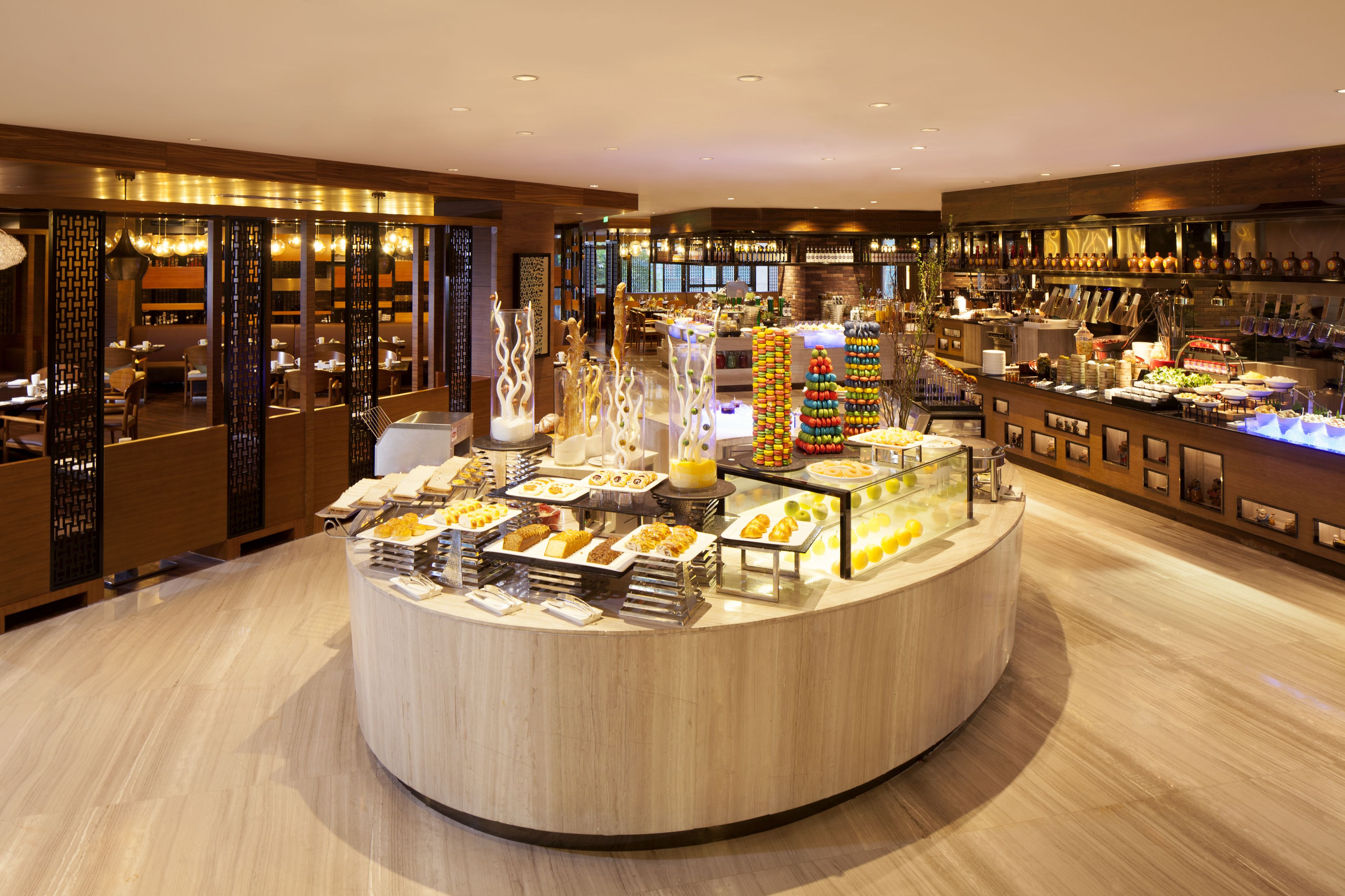 A buffet area with various food options, a bar with bottles, and a seating area with tables and chairs.