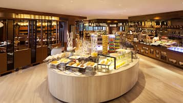 A buffet area with various food options, a bar with bottles, and a seating area with tables and chairs.