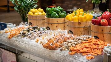 Exposição de frutos do mar com diversos tipos de mariscos e vegetais sobre gelo.