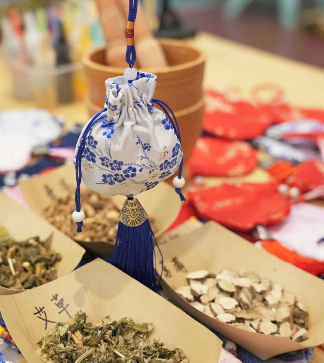 A traditional Chinese tea set with a teapot and cups, surrounded by loose tea leaves and tea bags.