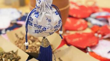 Un juego de té chino tradicional con tetera y tazas, rodeado de hojas de té sueltas y bolsitas de té.