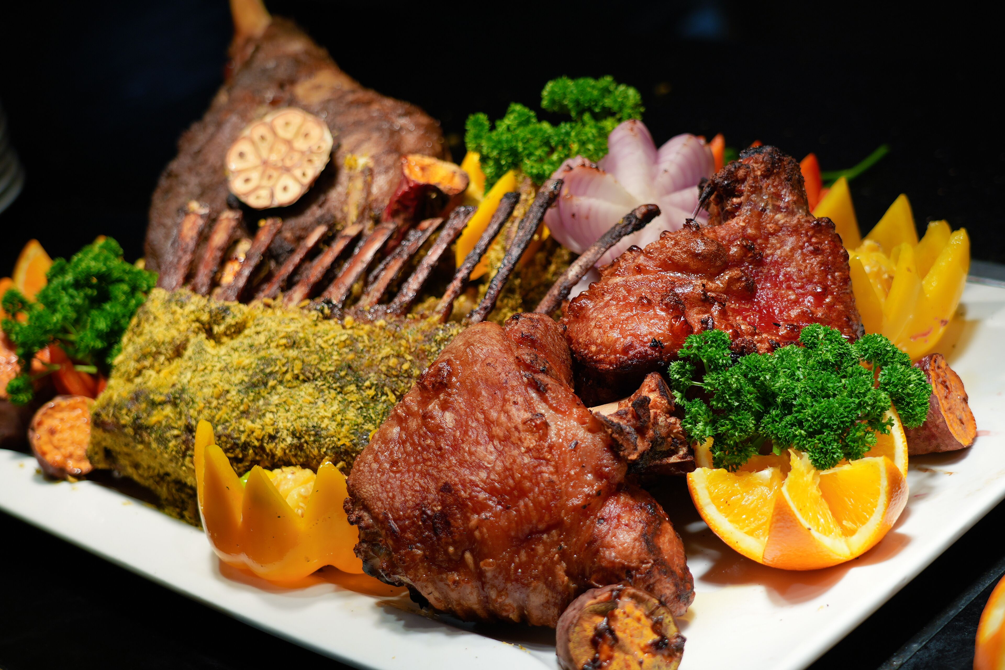 A roasted duck with crispy skin, garnished with parsley and orange slices, served on a white plate.