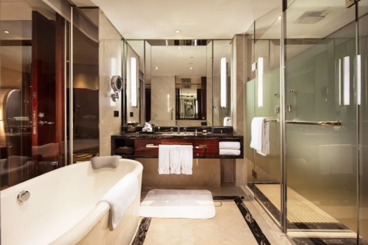 Un baño moderno con una bañera grande, cabina de ducha de vidrio y tocador con espejo.