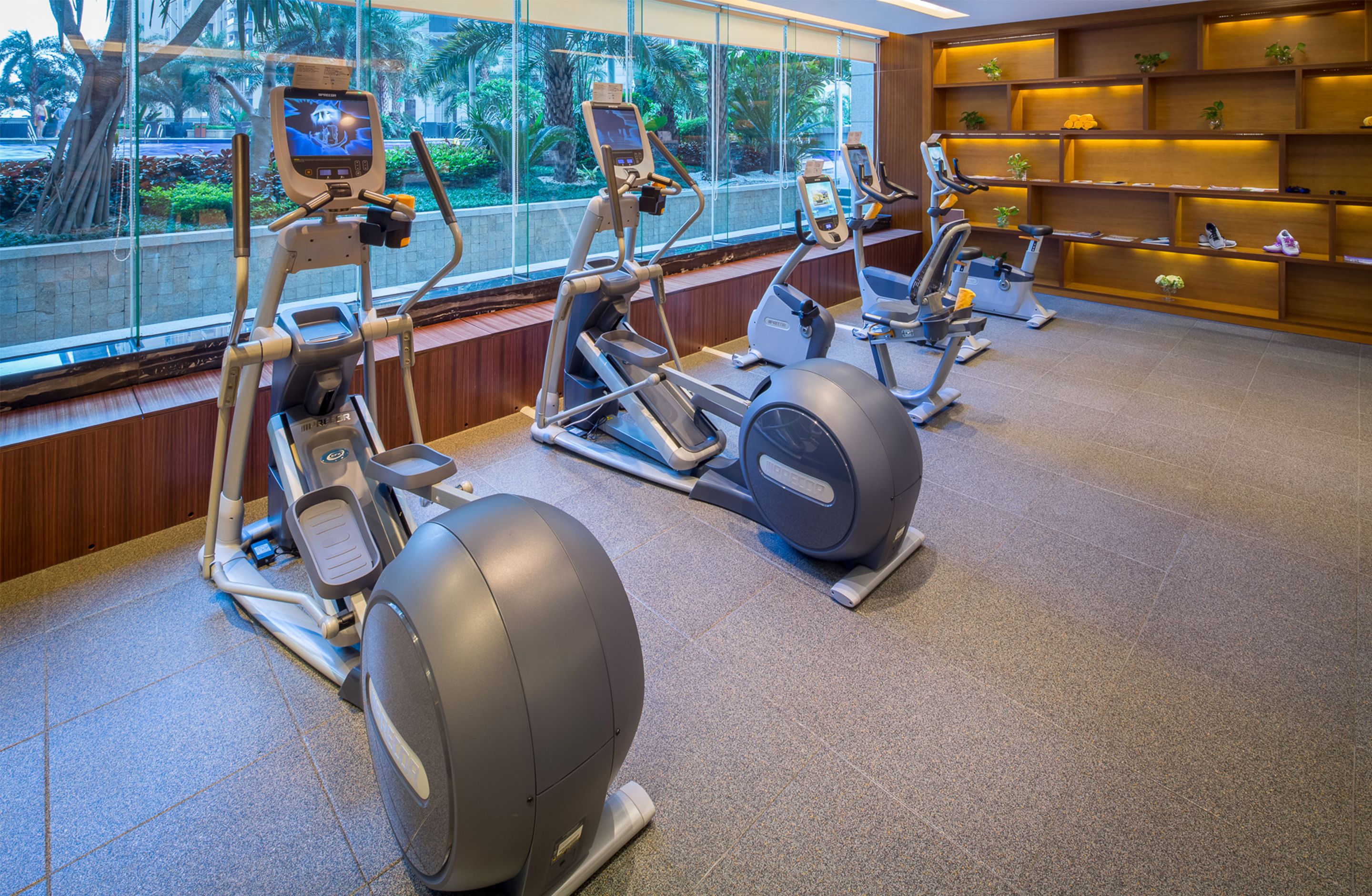 A gym with stationary bikes, a treadmill, and a rowing machine.