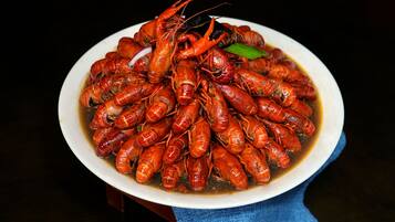 A plate of cooked crayfish with a dark background.