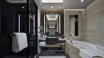 A modern bathroom with a glass-enclosed shower, a freestanding bathtub, and a vanity with a mirror.