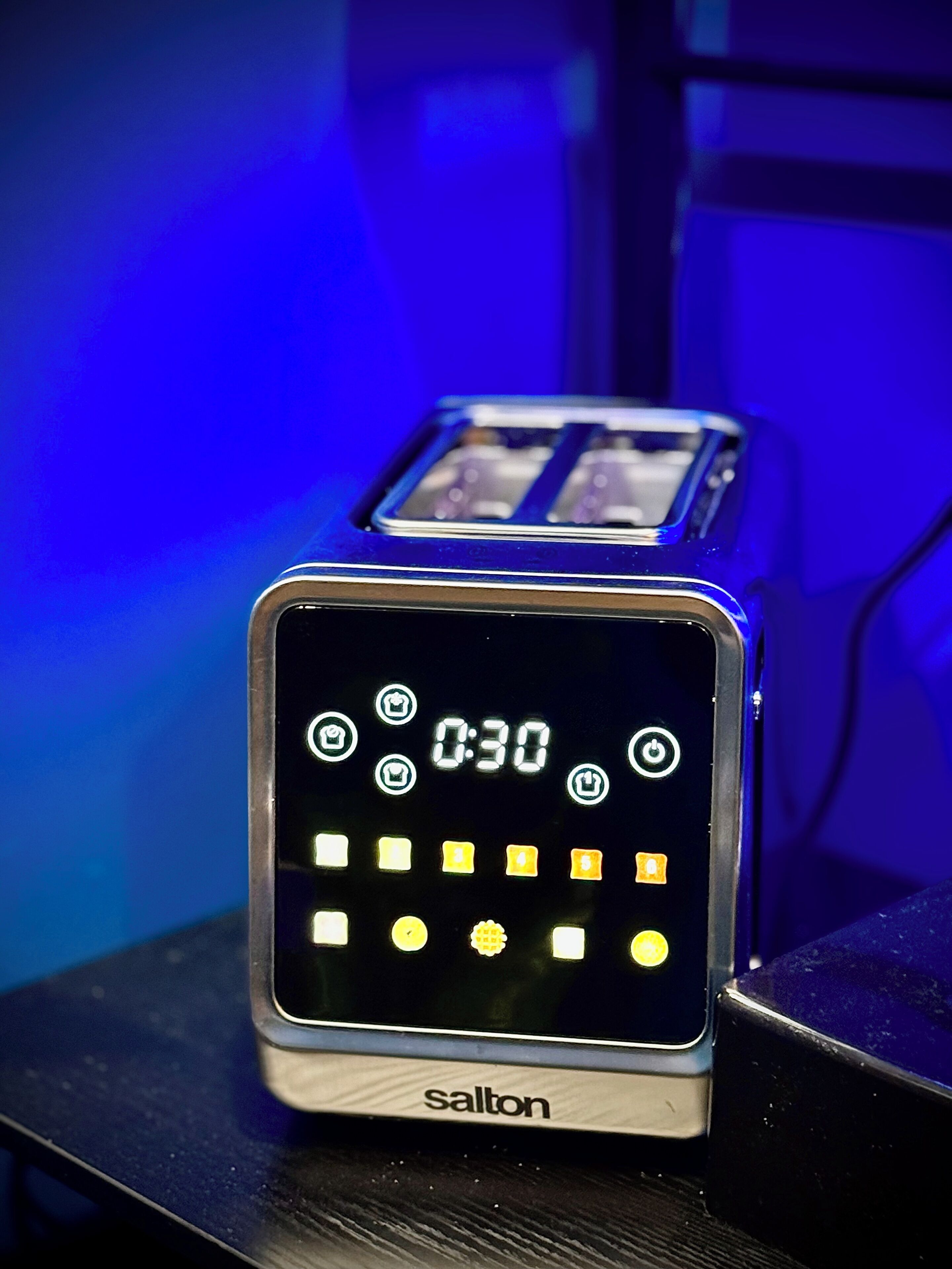 Eine digitale Uhr mit Anzeige von 0:30, der Marke 'salton' und verschiedenen Symbolen.
