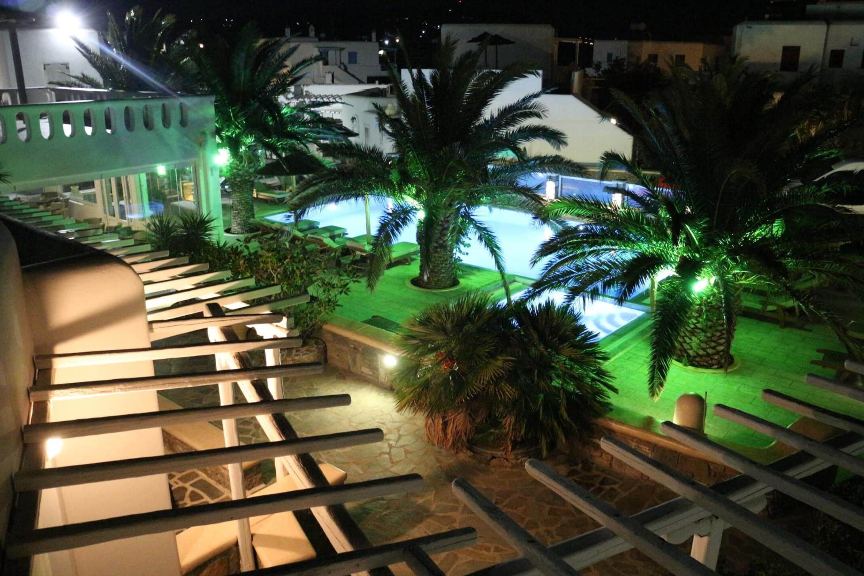 A pool area with palm trees and a staircase leading to a building.