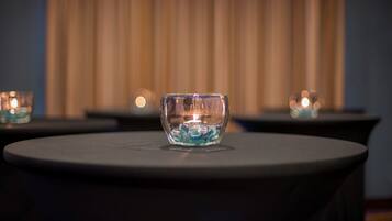 A glass bowl with a candle on a round table.