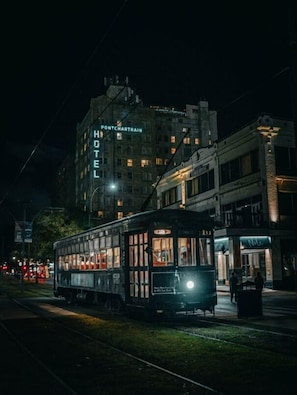 A tram at night near a building with a sign that reads "PONTCHARTRAIN HOTEL". - The Pontchartrain Hotel (New Orleans)