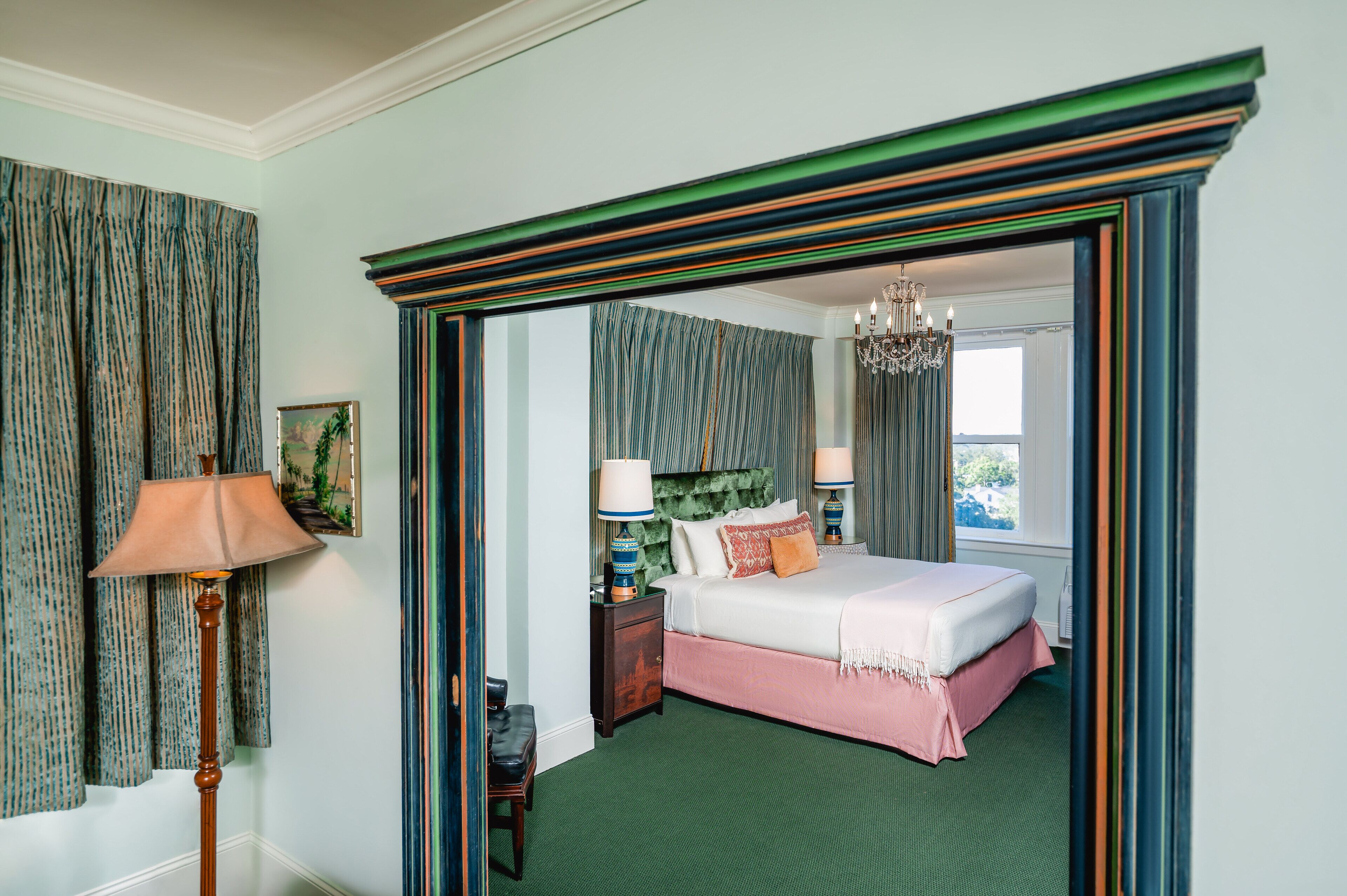 A bedroom with a bed, bedside tables, a lamp, and a window.